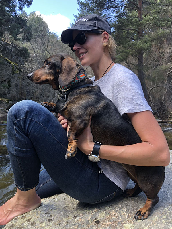 Chica con perro blanco al borde de un lago Chica con perro blanco al borde de un lago