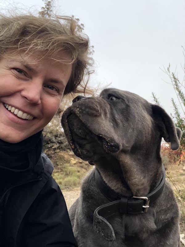 perro mira atentamente a su amo Chica con perro buldog gris que le mira